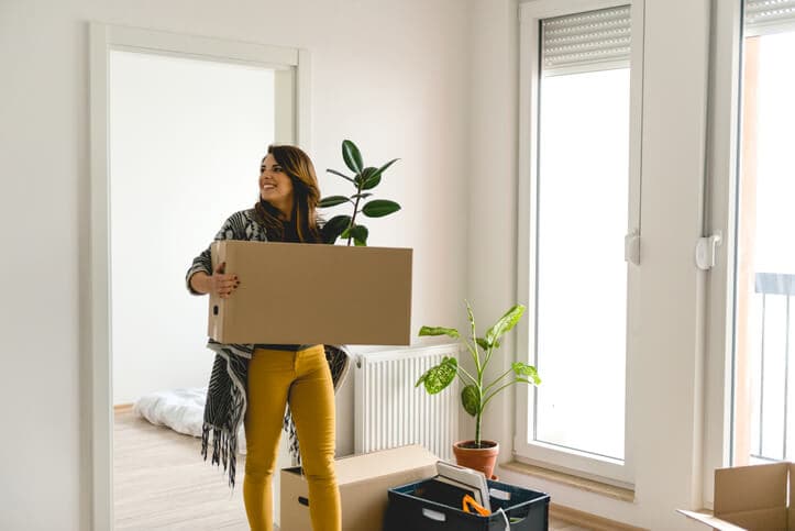 woman moving with large box out of apartment